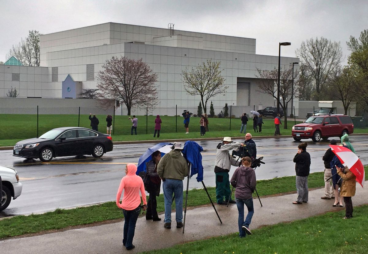 FILE - In this April 21, 2016, file photo, people stand outside the entertainer Prince's Paisley Park compound in Chanhassen, Minn. This week's public opening of Prince's suburban Minneapolis estate and studio complex likely will be delayed because the city council indefinitely postponed voting on a rezoning request for the complex to be operated as a museum. The Chanhassen City Council tabled the request Monday, Oct. 3. Paisley Park tours were due to begin Thursday, Oct. 6. (Jim Gehrz/Star Tribune via AP, File) (AP)