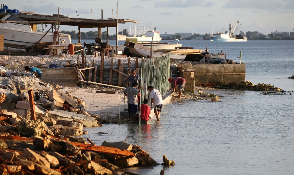 This Nov. 6, 2015, photo shows people building a sea wall on Majuro Atoll, Marshall. Rising seas in the Marshall Islands can be seen on many of the Atolls in the group as more coastline disappears and vegetation is washed away. The US military ignored warnings about rising seas to build a space radar costing nearly a billion dollars on a tiny atoll in the Marshall Islands. The Space Fence system is considered vital for keeping astronauts and satellites safe by tracking space junk as small as a baseball.(AP Photo/Rob Griffith) (AP)