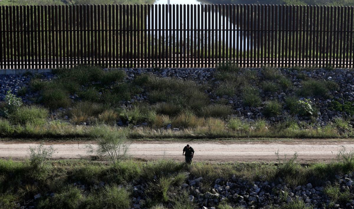In this Wednesday, Nov. 16, 2016, photo, a U.S. Customs and Border Patrol agent searches for suspected illegal immigrants passing through the area in Hidalgo, Texas. The idea of a concrete wall spanning the entire 1,954-mile southwest frontier collides head-on with multiple realities, like a looping Rio Grande, fierce local resistance, and cost. () (AP Photo/Eric Gay)