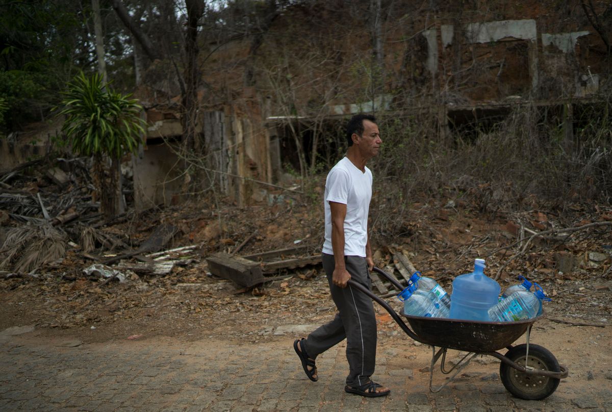 In this Oct. 11, 2016 photo, Lazimar Caliari pushes a wheelbarrow loaded with gallons of well water, in Colatina, Brazil. The 53-year-old musician is concerned about the quality of the water in the Doce River a year after a dam of mine waste broke, sending metal-laden mud into the Doce. "The mayor doesn't drink the water form the Doce River, so why should I have to drink it too?" asks Caliari. (AP Photo/Leo Correa) (AP)