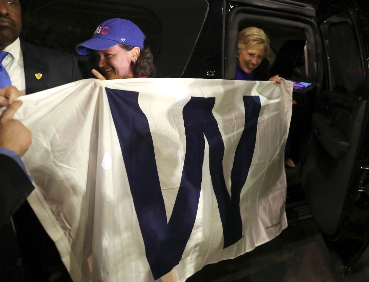 Democratic presidential candidate Hillary Clinton holds a 'W' banner as the Chicago Cubs win the World Series baseball Game 7 against the Cleveland Indians after her final campaign rally of the day at Arizona State University in Tempe, Ariz., Wednesday, Nov. 2, 2016. (AP Photo/Andrew Harnik) (AP)