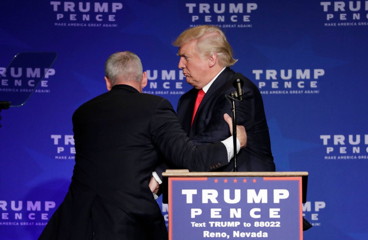 Members of the Secret Service rush Republican presidential candidate Donald Trump off the stage at a campaign rally in Reno, Nev., on Saturday, Nov. 5, 2016. (AP Photo/John Locher) (AP Photo/John Locher)