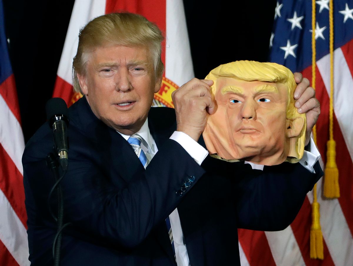 Republican presidential candidate Donald Trump holds up a Donald Trump mask during a campaign speech, Monday, Nov. 7, 2016, in Sarasota, Fla.  (AP)