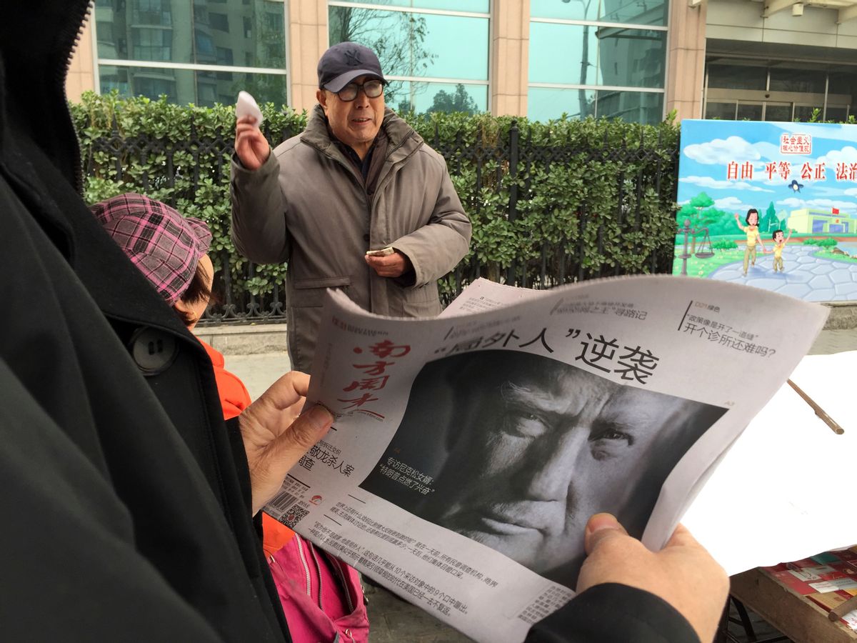 A Chinese man holds up a Chinese newspaper with the front page photo of U.S. President-elect Donald Trump and the headline "Outsider counter attack" at a newsstand in Beijing, China, Thursday, Nov. 10, 2016. Trump is a mixed blessing for Chinese leaders. His threats to tear up trade deals and hike tariffs on Chinese goods could chill thriving commercial ties when Beijing is struggling to shore up economic growth. At the same time, Trump’s suggestion he might reduce Washington’s global strategic presence to focus on domestic issues would be a gift to Chinese leaders. They could expand their political and military profile in East Asia with less risk of conflict. () (AP Photo/Ng Han Guan)