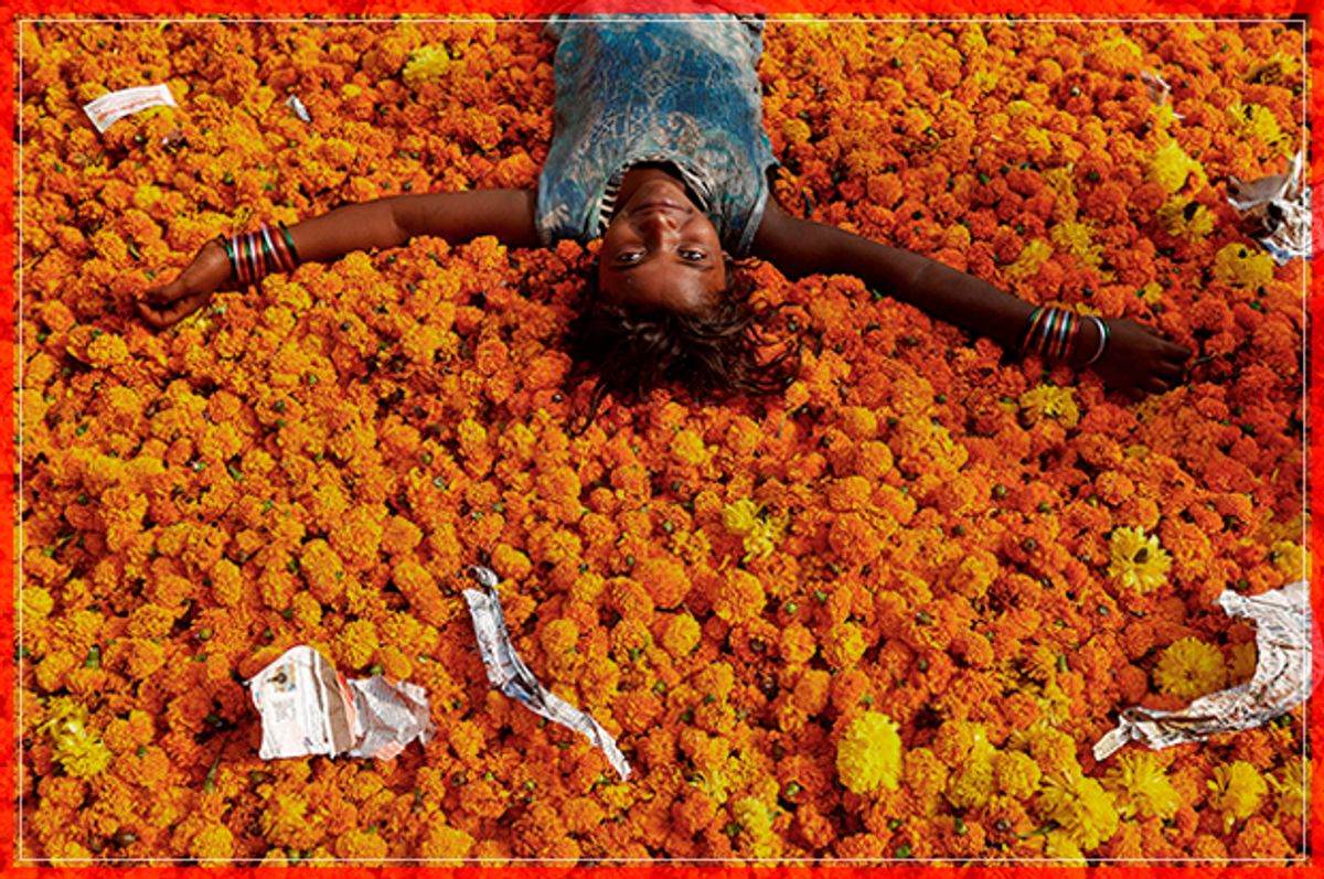 A girl plays on a pile of discarded flowers outside a market, the day after the Diwali celebrations in Mumbai, India October 31, 2016. REUTERS/Shailesh Andrade - RTX2R7MP (Reuters)