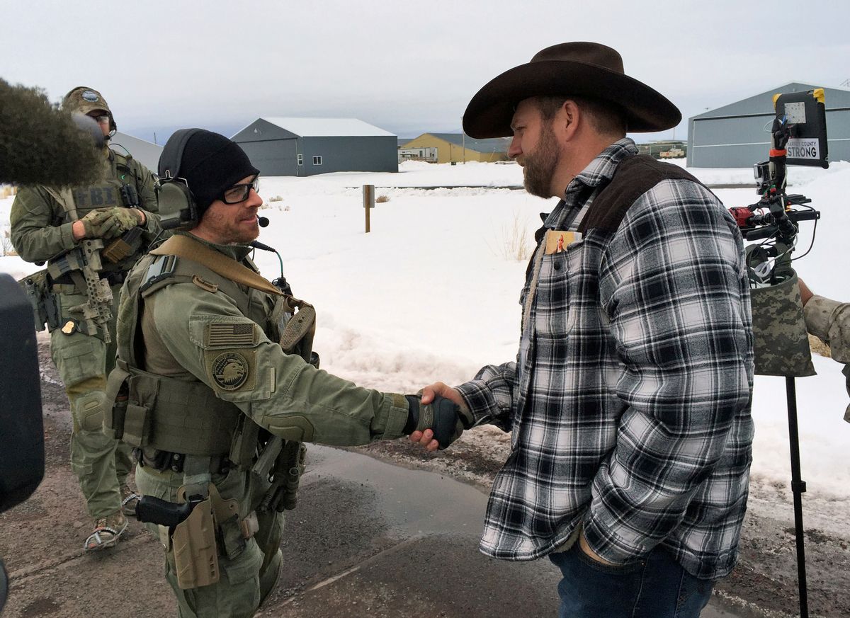 FILE - In this Jan. 22, 2016, file photo, Ammon Bundy, right, shakes hand with a federal agent guarding the gate at the Burns Municipal Airport in Burns, Ore. Bundy, the leader of a federal wildlife refuge takeover in Oregon says his group will "continue to stand" after he and six others were acquitted last week in Portland, Ore., of charges in the case. Bundy remains in jail because he still faces charges in the 2014 standoff at his father's Nevada ranch. (AP Photo/Keith Ridler, File) (AP)