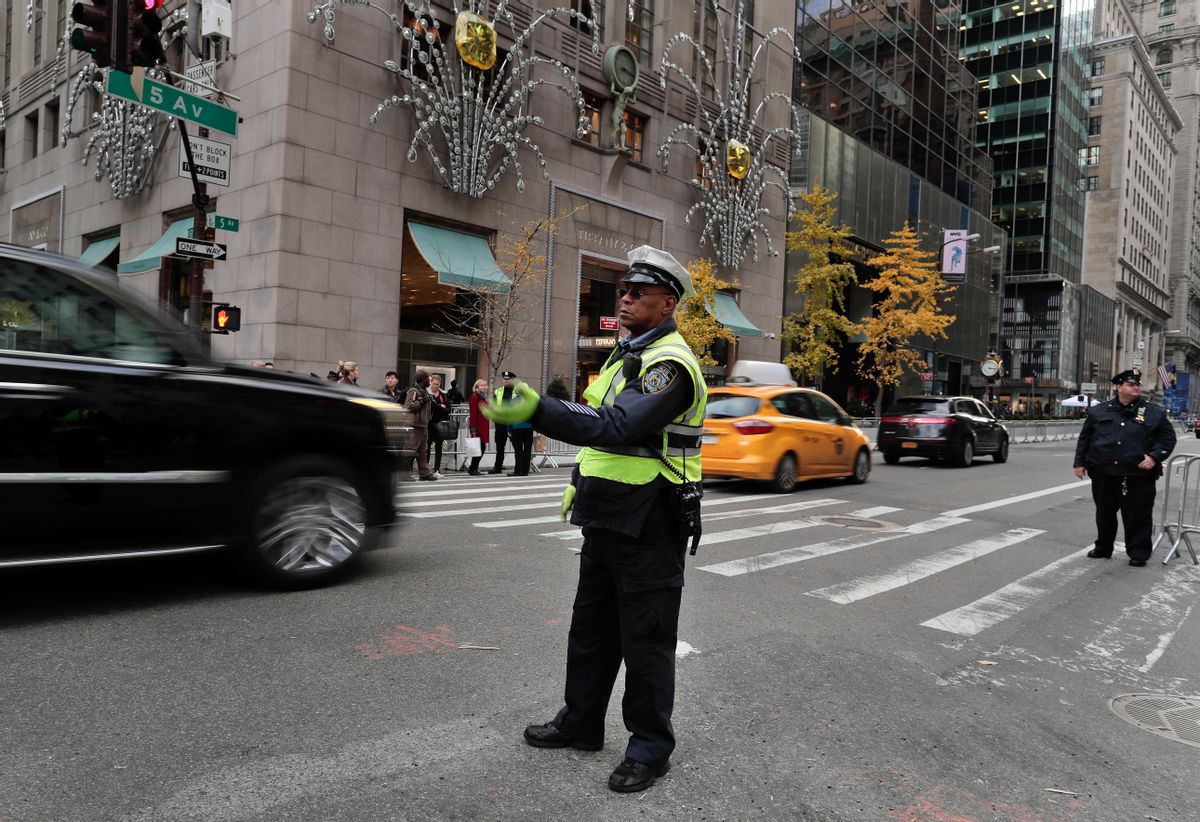 A New York police officer directs traffic along Fifth Avenue where lanes were closed in front of Trump Tower where President-elect Donald Trump continued meetings with members of his transition team, Wednesday, Nov. 16, 2016, in New York. (AP Photo/Julie Jacobson) (AP)