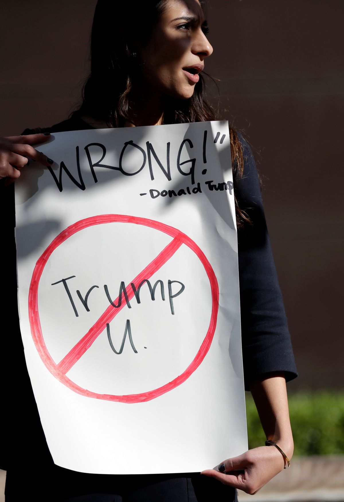 Senya Merchant holds a sign against President-elect Donald Trump's now-defunct Trump University Friday, Nov. 18, 2016, in San Diego.  (AP)