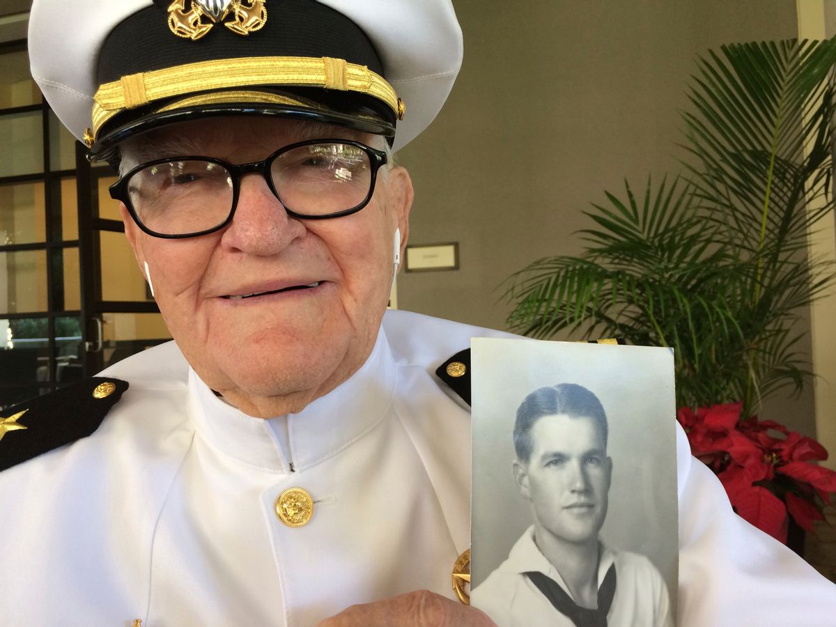 In this Monday, Dec. 5, 2016 photo, Jim Downing, 103, poses in a Navy uniform in Honolulu, with a photo of himself taken when he was about 20 years old. Downing is among a few dozen survivors of the Japanese attack on Pearl Harbor who plan to gather at the Hawaii naval base Wednesday, Dec. 7, 2016, to remember those killed 75 years ago. (AP Photo/Audrey McAvoy) (AP)