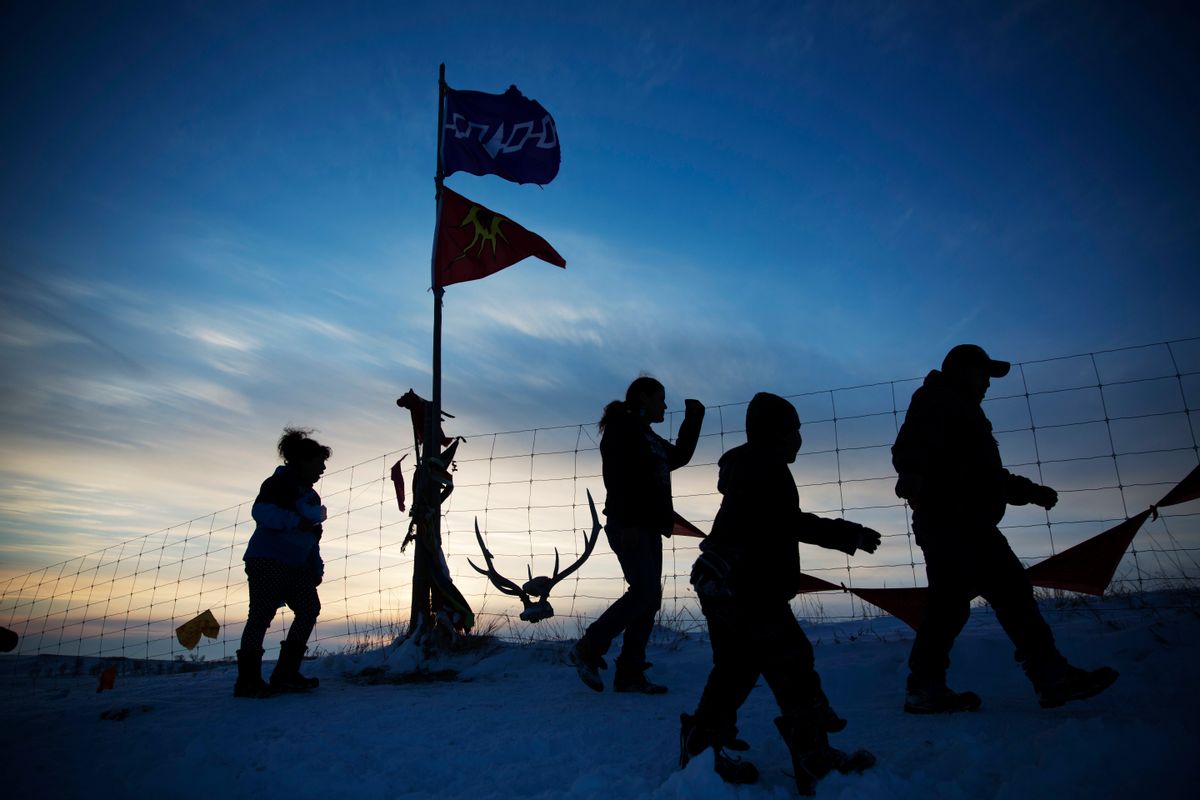A Native American tribal flag stands atop a hill overlooking the Oceti Sakowin camp where people have gathered to protest the Dakota Access oil pipeline in Cannon Ball, N.D., Saturday, Dec. 3, 2016. (AP Photo/David Goldman) (AP)