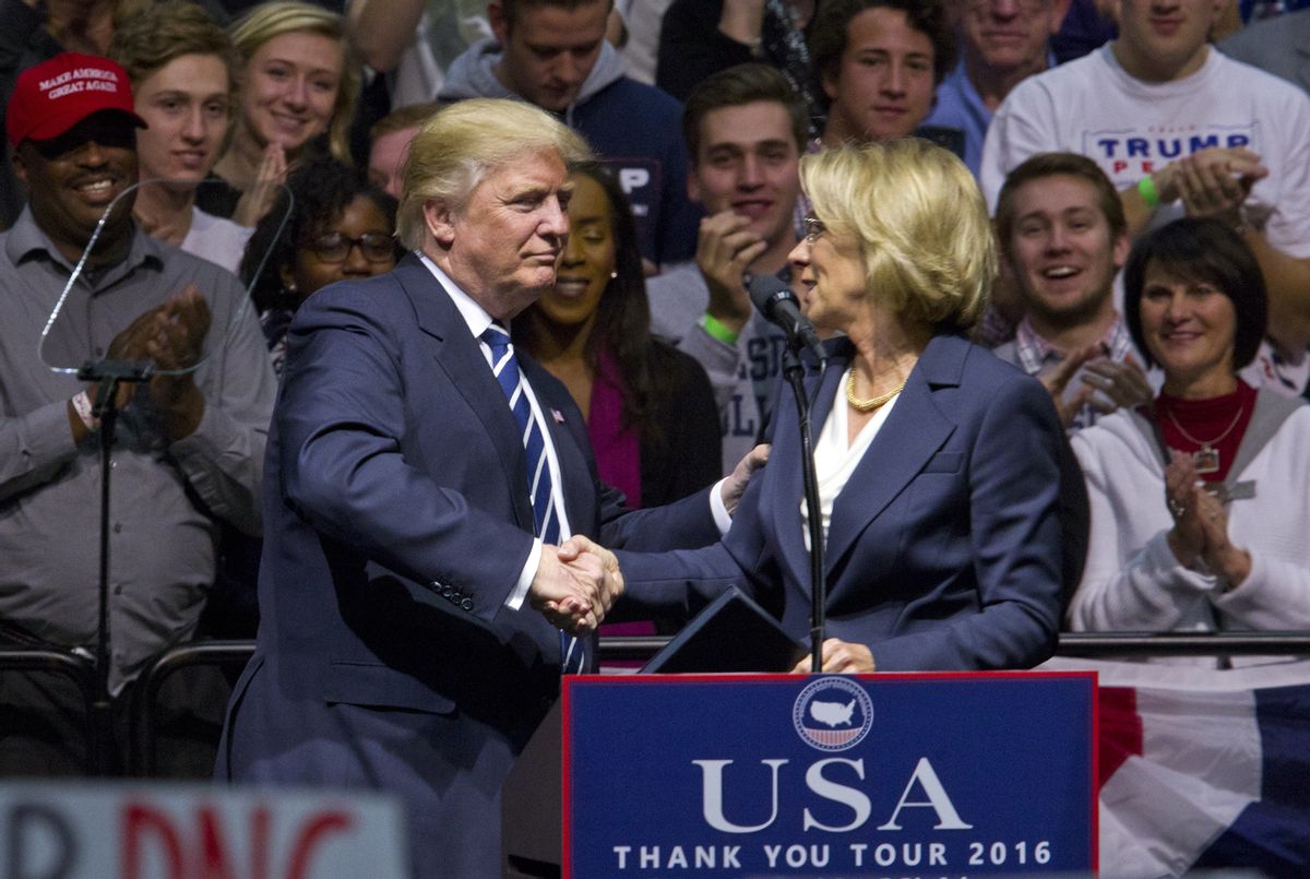President-elect Donald J. Trump greets Betsy DeVos, his choice for education secretary, during his "USA Thank You Tour" at the DeltaPlex in Walker, Mich., Friday, Dec. 9, 2016. (Cory Morse/The Grand Rapids Press-MLive.com via AP) (AP)