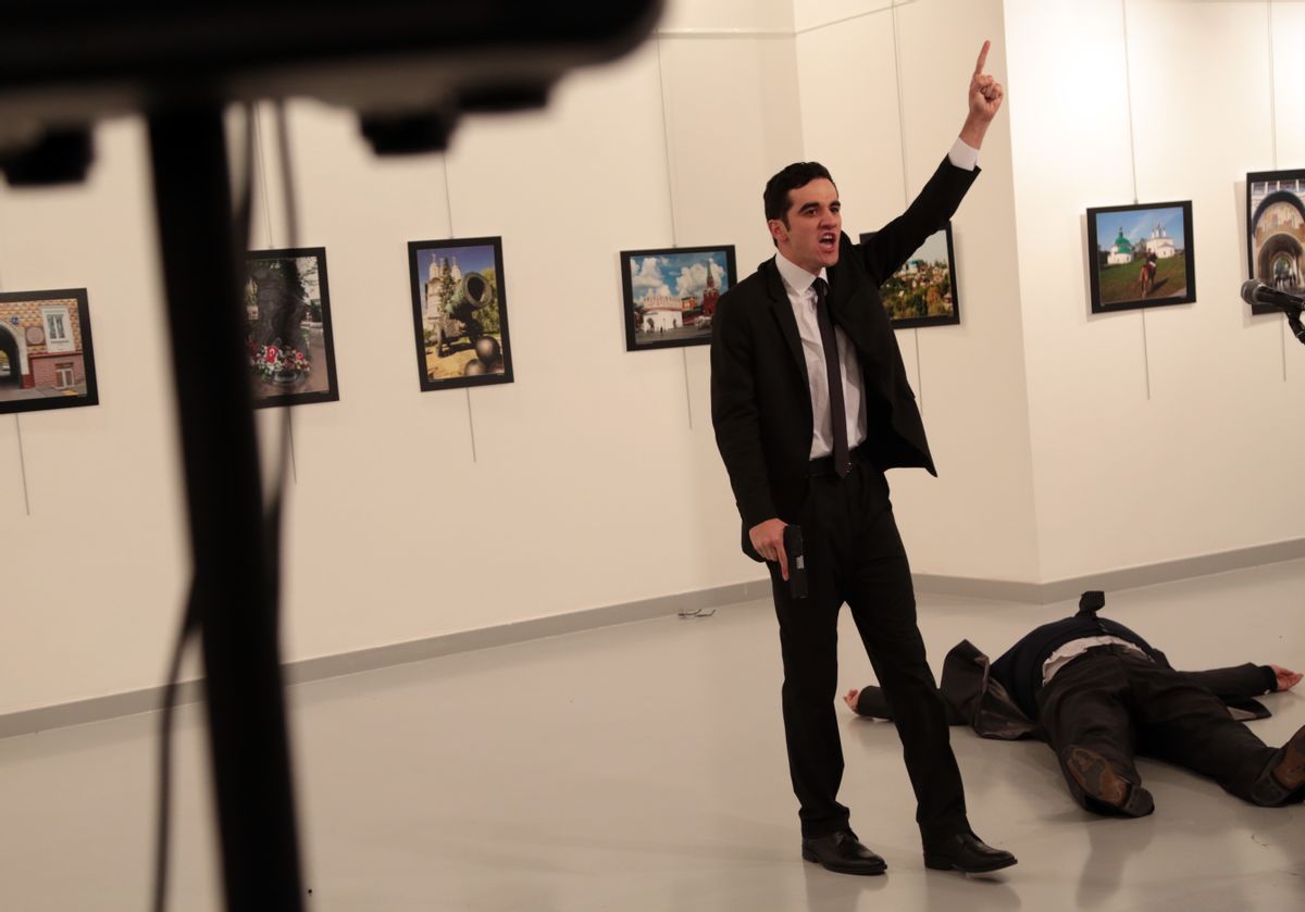 A man gestures near to the body of a man at a photo gallery in Ankara, Turkey, Monday, Dec. 19, 2016. An Associated Press photographer says a gunman has fired shots at the Russian ambassador to Turkey. The ambassador's condition wasn't immediately known. (AP Photo/Burhan Ozbilici) (AP)