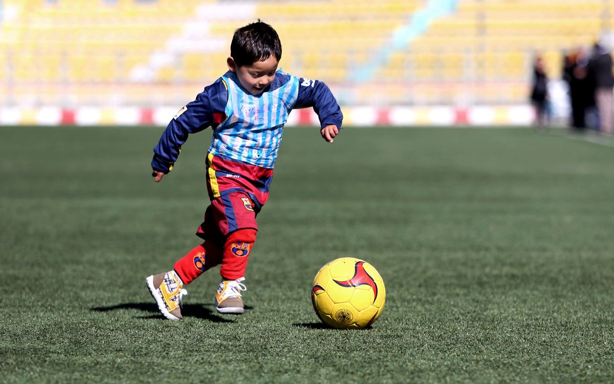 FILE - In this Feb. 2, 2016, file photo, Murtaza Ahmadi, a five-year-old Afghan Lionel Messi fan plays soccer, at the Afghan Football Federation Stadium in Kabul, Afghanistan. The Afghan Football Federation set up a meeting between Messi and Ahmadi who became an Internet sensation when photos circulated of him wearing an improvised Messi shirt made from a plastic bag. (AP Photo/Rahmat Gul, File) (AP Photo/Rahmat Gul, File)