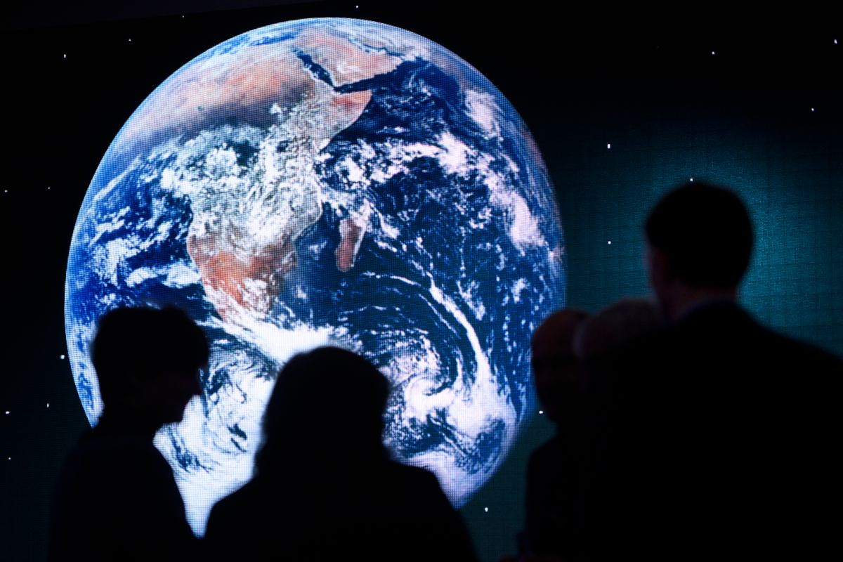 Participants are silhouetted against a picture of the planet Earth on a giant screen during a panel session on the closing day of the 47th annual meeting of the World Economic Forum, WEF, in Davos, Switzerland, Friday, Jan. 20, 2017. (Laurent Gillieron/dpa via AP) (AP)