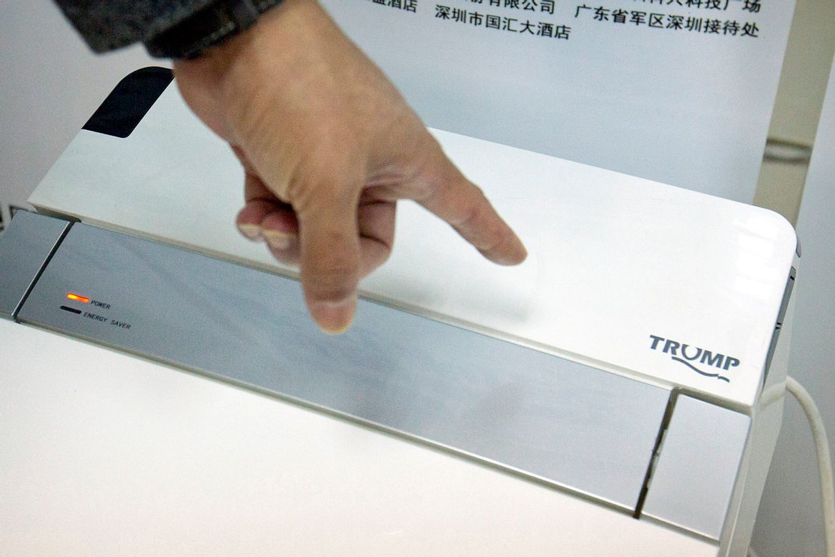 In this Monday, Feb. 13, 2017 photo, Zhong Jiye, a co-founder of Shenzhen Trump Industrial Co., points to the logo on one of his firm's high-end Trump-branded toilets at the company's offices in Shenzhen in southern China's Guangdong Province. U.S. President Donald Trump is poised to receive something that he had been trying to get from China for more than a decade: trademark rights to his own name. After suffering rejection after rejection in China's courts, he saw his prospects change dramatically after starting his presidential campaign. (AP Photo/Mark Schiefelbein) (AP)