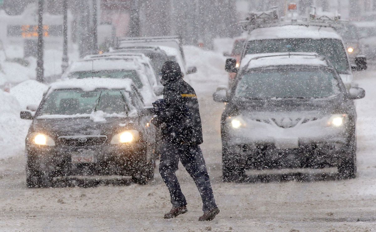 A pedestrian crosses the street in front of vehicles during a snowstorm, Sunday, Feb. 12, 2017, in Waltham, Mass. (AP Photo/Steven Senne) (AP)