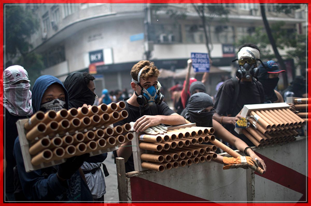 Demonstrators holding fireworks as weapons stand behind a barricade during clashes with police as they protest the state government in Rio de Janeiro, Brazil, Thursday, Feb. 9, 2017.  The protesters are denouncing a proposal to privatize the state's water and sewage company. (AP Photo/Felipe Dana) (AP)
