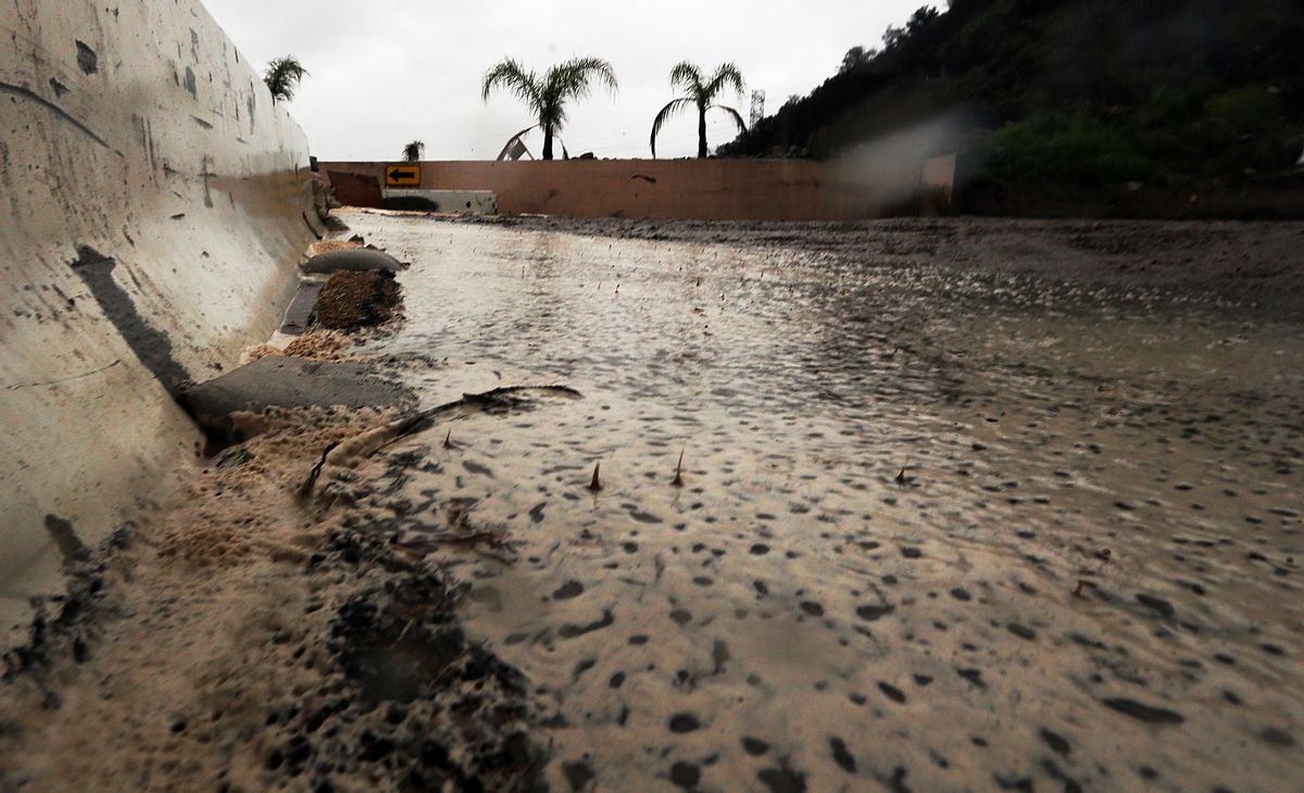 Raindrops splash in water, mud and debris in a basin slowly filling up in Duarte, Calif., in a threatened area below a burn area know as the Fish Fire, as a powerful storm moves into Southern California Friday, Feb. 17, 2017. The saturated state faces a new round of wet weather that could trigger flooding and debris flows. (AP Photo/Reed Saxon) (AP Photo/Reed Saxon)