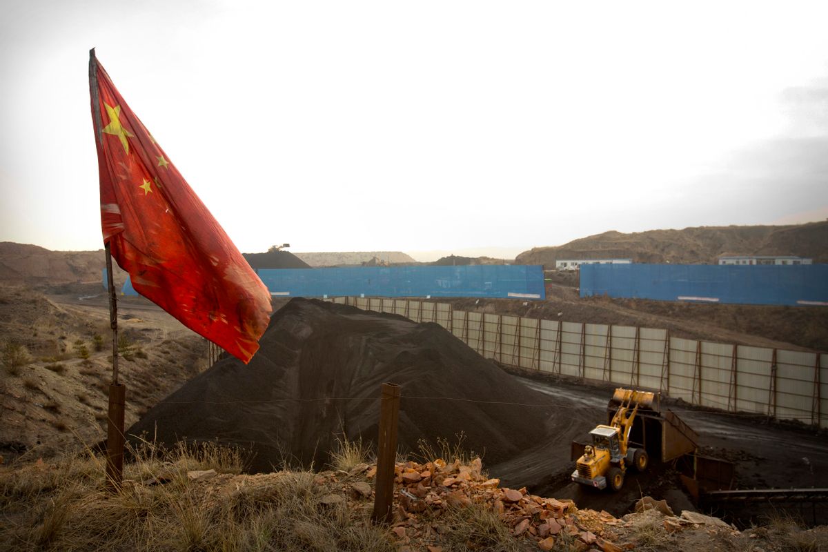 FILE - In this Nov. 4, 2015 file photo, a Chinese flag moves in the breeze as a loader moves coal at a coal mine near Ordos in northern China's Inner Mongolia Autonomous Region. (AP Photo/Mark Schiefelbein, File) (AP)