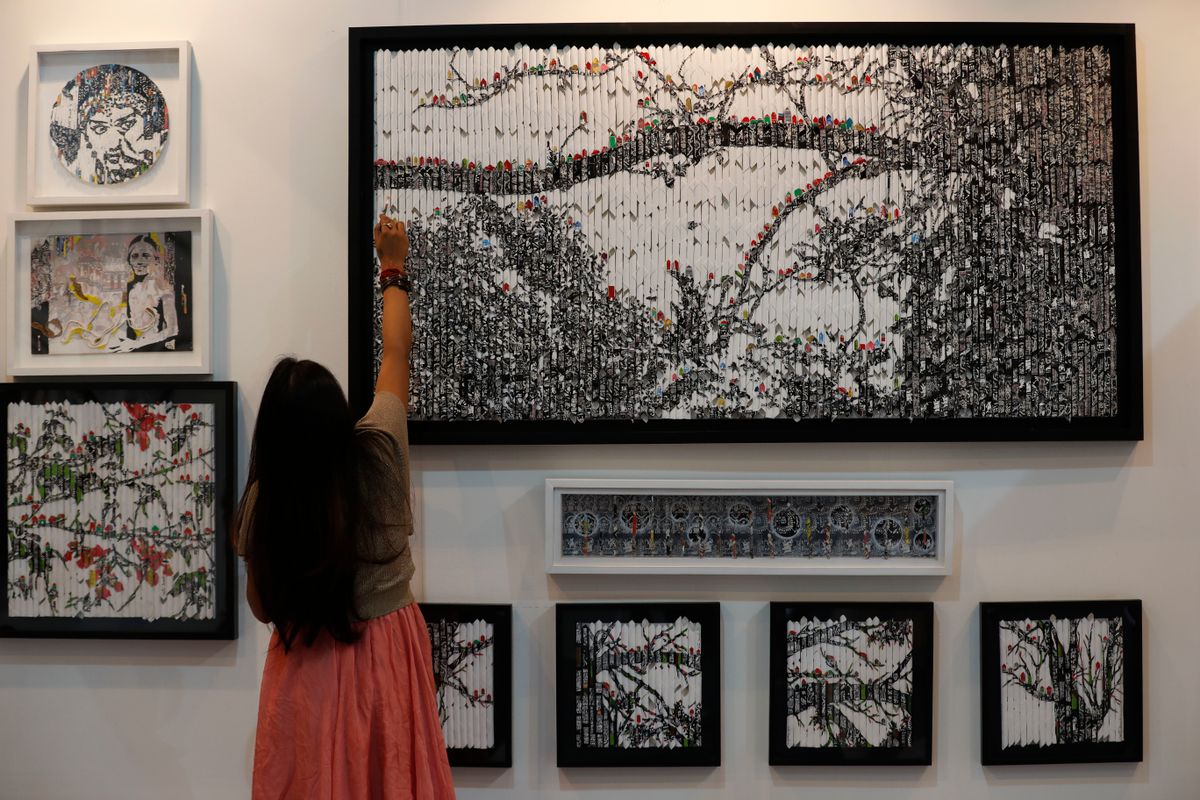 Vinila Dasgupta retouches her art during India Art Fair in New Delhi, India, Thursday, Feb. 2, 2017. The four day art fair brings together a number of modern and contemporary artists to present their works. ( (AP Photo/Tsering Topgyal))