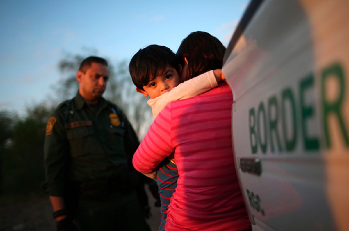 A one-year-old from El Salvador clings to his mother after she turned themselves in to Border Patrol agents on December 7, 2015 near Rio Grande City, Texas   (Getty/John Moore)