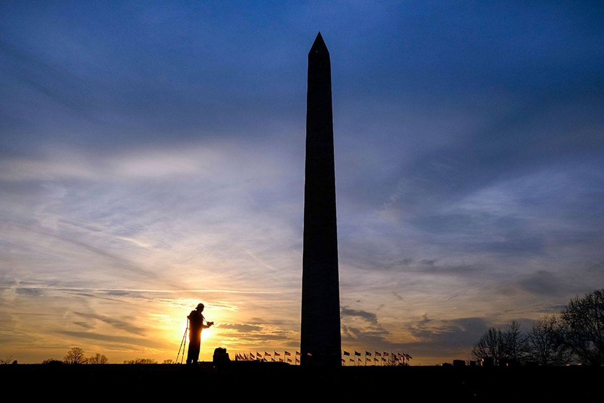 Silhouetted in the setting sun, a photographer works with his camera in the shadow of the Washington Monument, Tuesday, Feb. 21, 2017. The monument to honor the first U.S. President, George Washington, was dedicated 132 years ago today on Feb. 21, 1885. It was open to the public three years later and remains by law the tallest structure in the District of Columbia. (AP Photo/J. David Ake) (AP)