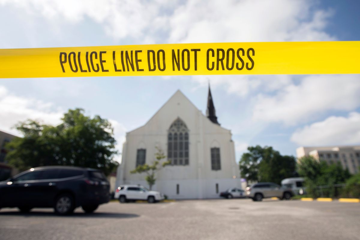 FILE - In this Friday, June 18, 2015 file photo, police tape surrounds the parking lot behind the AME Emanuel Church as FBI forensic experts work the crime scene where nine people where shot by Dylann Storm Roof, 21, in Charleston, S.C. Since the Oklahoma City bombing in 1995, the Southern Poverty Law Center has tracked domestic terrorist plots and attacks in the United States. It lists more than 100, including the slaying of nine black churchgoers during a 2015 prayer meeting in Charleston, S.C. (AP Photo/Stephen B. Morton, File) (AP)