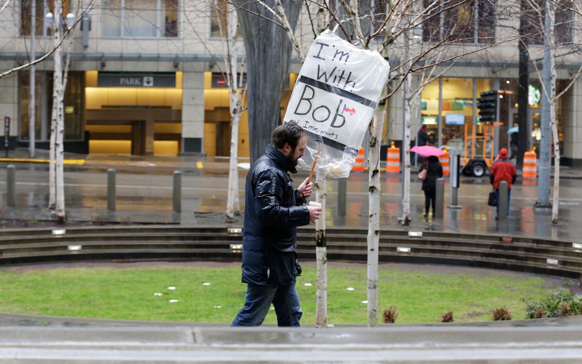 A person walks outside the federal courthouse in Seattle carrying a sign that reads "I'm with Bob and Immigrants," in reference to Washington state Attorney General Bob Ferguson, Friday, Feb. 3, 2017, during a hearing in federal court. A U.S. judge on Friday temporarily blocked President Donald Trump's ban on people from seven predominantly Muslim countries from entering the United States after Washington state and Minnesota urged a nationwide hold on the executive order that has launched legal battles across the country. (AP Photo/Ted S. Warren) (AP)