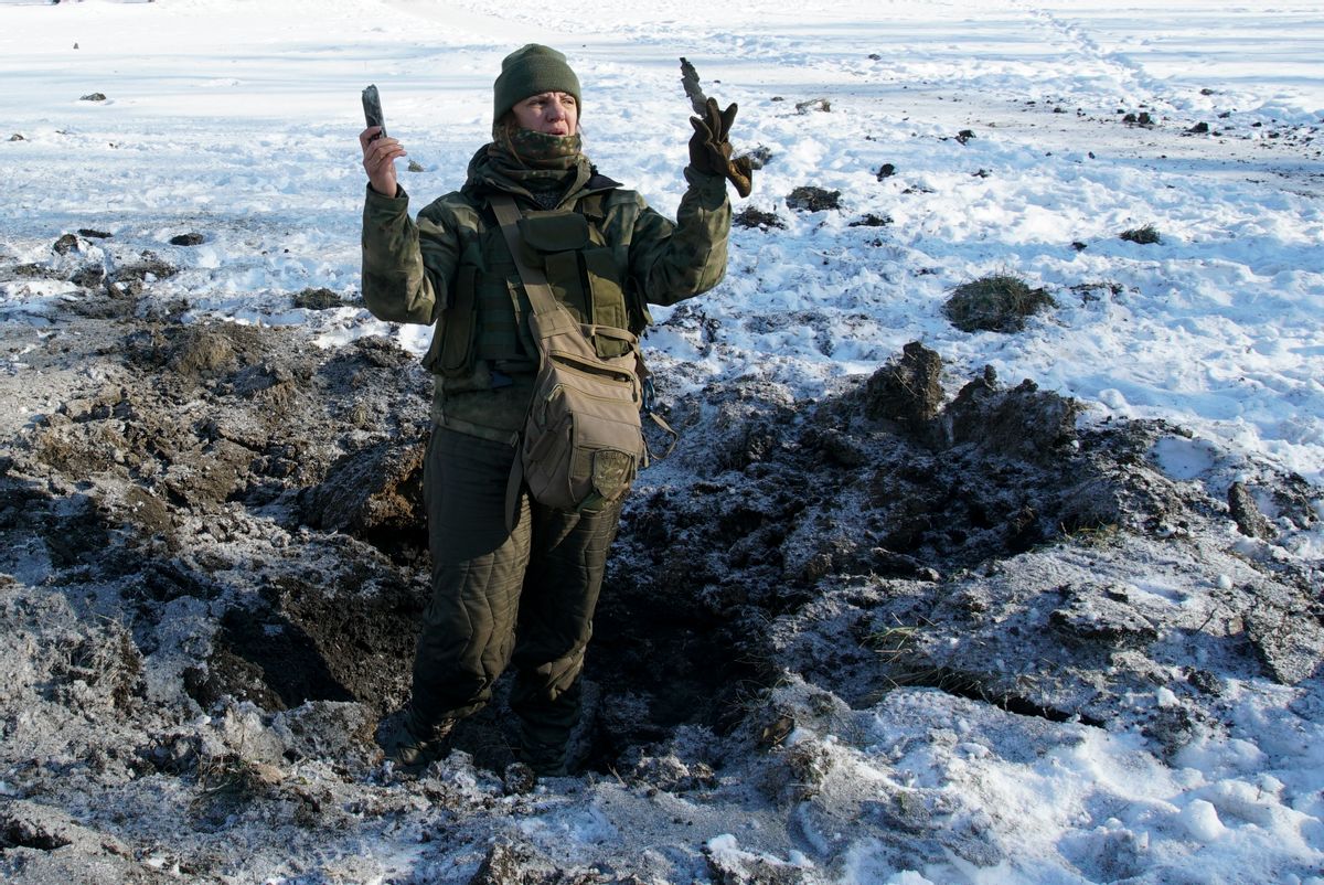 A Ukrainian soldier shows pieces of shrapnel in a crater left by an explosion in Avdiivka, Ukraine, Tuesday, Jan. 31, 2017. Fighting between government troops and Russia-backed separatist rebels in eastern Ukraine escalated on Tuesday, killing at least eight people late Monday and early Tuesday, injuring dozens and briefly trapping more than 200 coal miners underground, the warring sides reported.() (AP Photo/Inna Varenytsia)