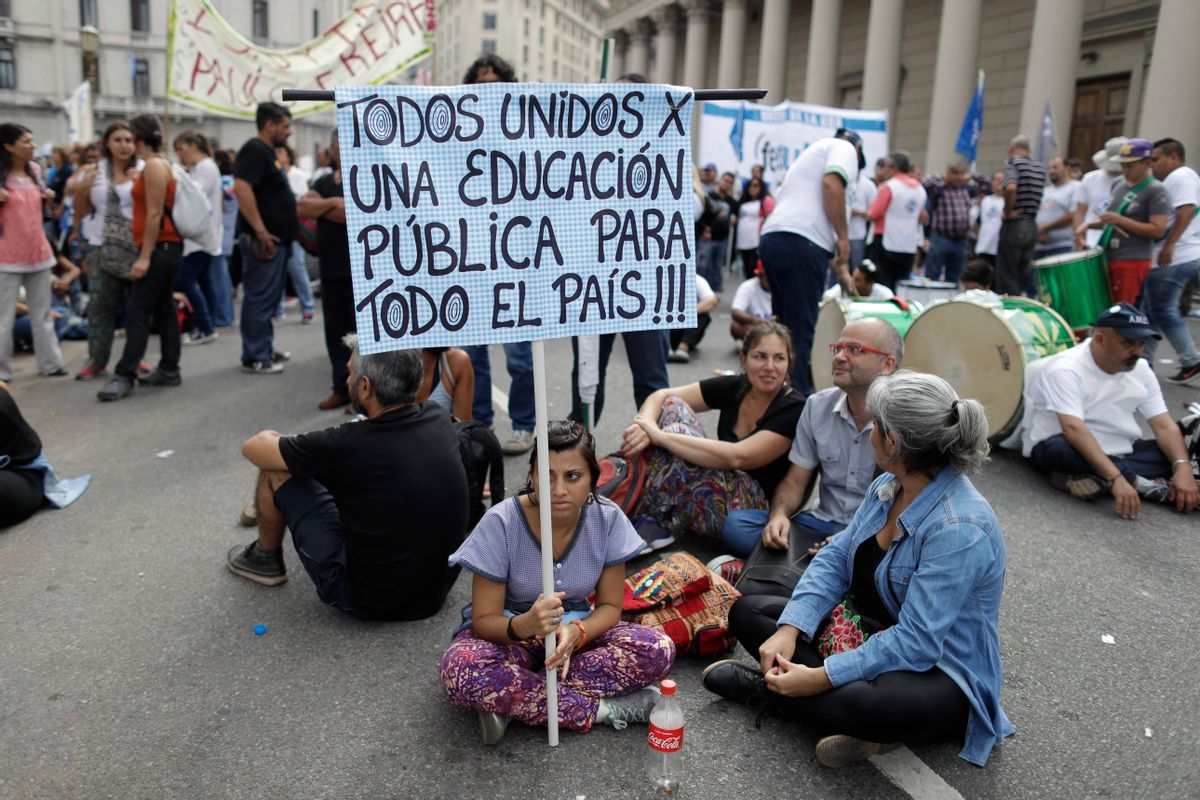 A teacher holds a sign with a message that reads in Spanish: "All united for public education for the entire country", during a protest demanding higher wages in Buenos Aires, Argentina, Wednesday, March 22, 2017. Tens of thousands of teachers marched to Plaza de Mayo, the park overlooking the presidential palace, during their fourth day of national strike. (AP Photo/Victor R. Caivano) (AP)