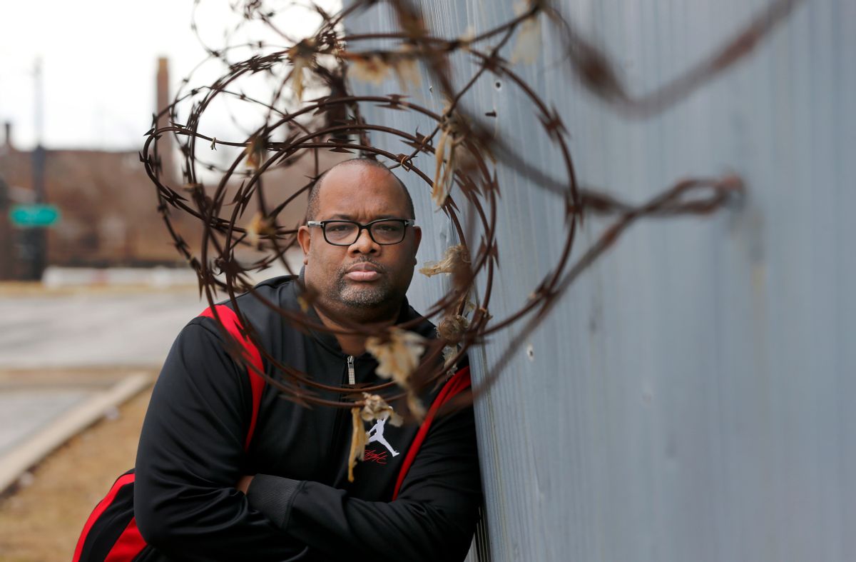 In this Tuesday, Feb. 21, 2017, photo, Pastor Corey Brooks of the New Beginnings Church poses for a portrait on a under maintained security wall that hugs the sprawling Norfolk Southern train yard and his church on Chicago's South Side. When street-gang thieves slipped into a Norfolk Southern rail yard on Chicago's South Side and ripped locks off one train, they likely expected to see merchandise like toys or tennis shoes. What they beheld instead was a gangster’s jackpot: box after box of brand new guns. (AP Photo/Charles Rex Arbogast) (AP)