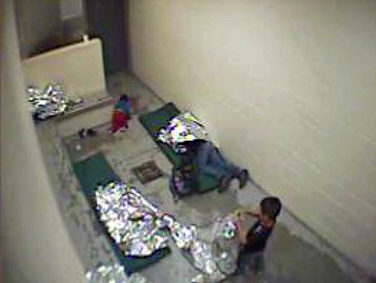 FILE- This September, 2015 file image made from U.S. Border Patrol surveillance video shows a child crawling on the concrete floor near the bathroom area of a holding cell, and a woman and children wrapped in Mylar sheets at a U.S. Customs and Border Protection station in Douglas, Ariz. A federal judge says the Border Patrol in Arizona violated court orders by failing to properly keep surveillance video pertaining to a lawsuit claiming the agency holds migrants in inhumane conditions. Judge David Bury partially granted a motion on Monday, March 13, to hold the Border Patrol's Tucson Sector in civil contempt over video files it was legally required to provide but which were irreparably damaged.(U.S. Border Patrol via AP, File) (AP)