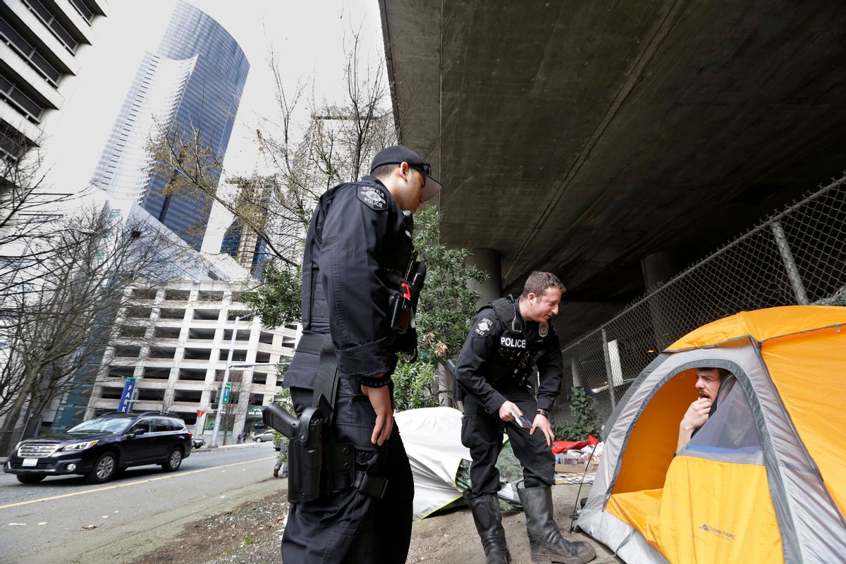 In this photo taken Thursday, March 23, 2017, Seattle police officers Wes Phillips, left, and Tori Newborn talk with Corvin Dobschutz as part of a new team of outreach workers and officers that go out and connect homeless people to services, as the homeless man sits in his tent below a freeway and next to downtown Seattle. (AP Photo/Elaine Thompson) (AP)
