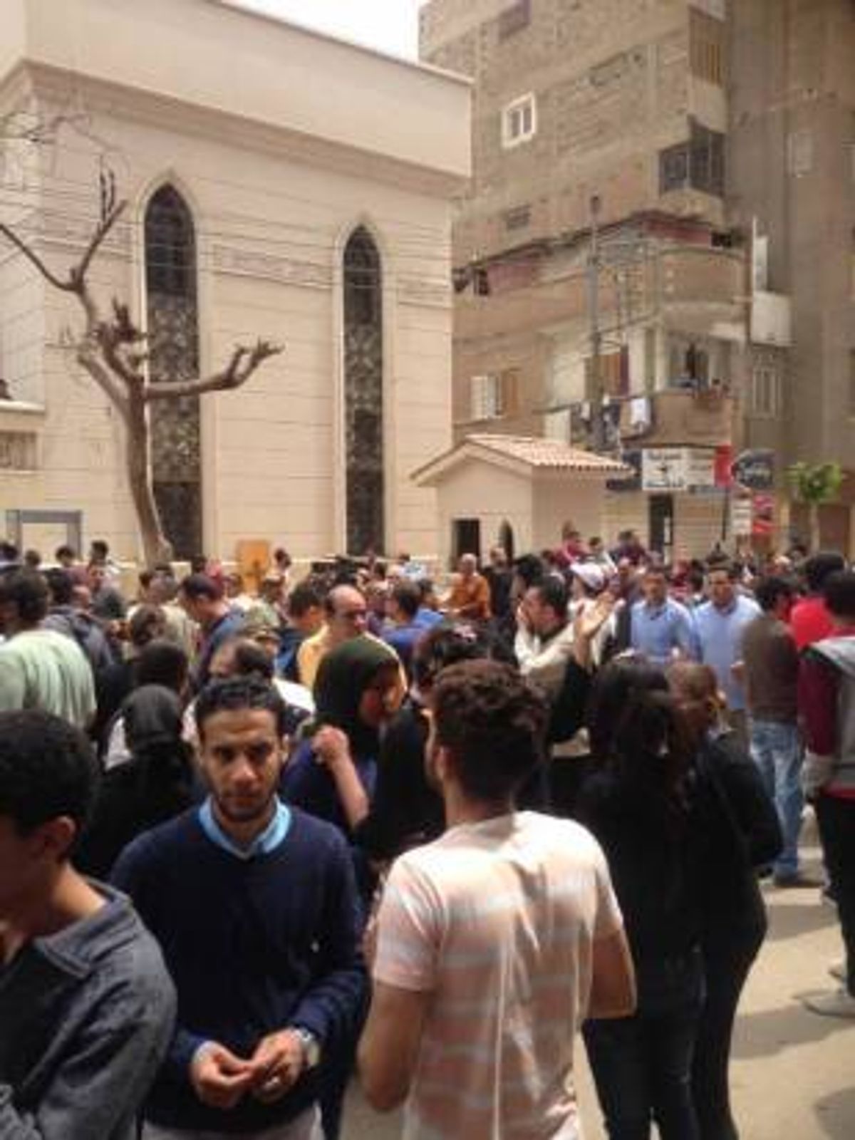 Relatives and onlookers gather outside a church after a bomb attack in the Nile Delta town of Tanta, Egypt. (AP)