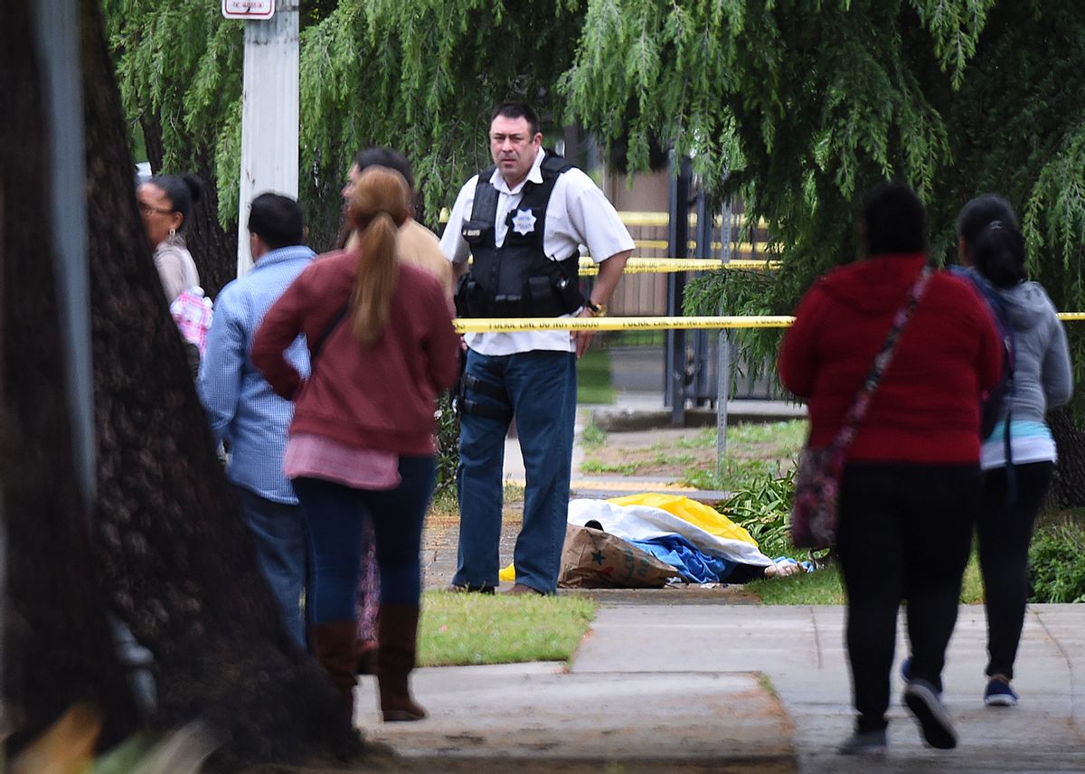 A Fresno police detective stands over the body of one of the three shooting victims Tuesday, April 18, 2017 in Fresno, Calif. A man shot and killed three people on the streets of downtown Fresno on Tuesday, shouting "God is great" in Arabic during at least one of the slayings and later telling police that he hates white people, authorities said. Kori Ali Muhammad, 39, was arrested shortly after the rampage, whose victims were all white, police said. He also was wanted in connection with another killing days earlier, in which a security guard was gunned down at a Fresno motel after responding to a disturbance.(John Walker/Fresno Bee via AP) (AP)