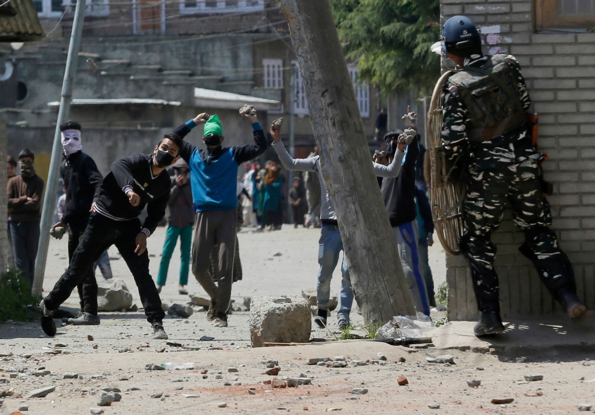 Kashmiri protesters throw stones on Indian security men outside a poling station during a by-election to an Indian Parliament seat in Srinagar, Indian controlled Kashmir, Sunday, April. 9, 2017. (AP Photo/Mukhtar Khan) (AP)