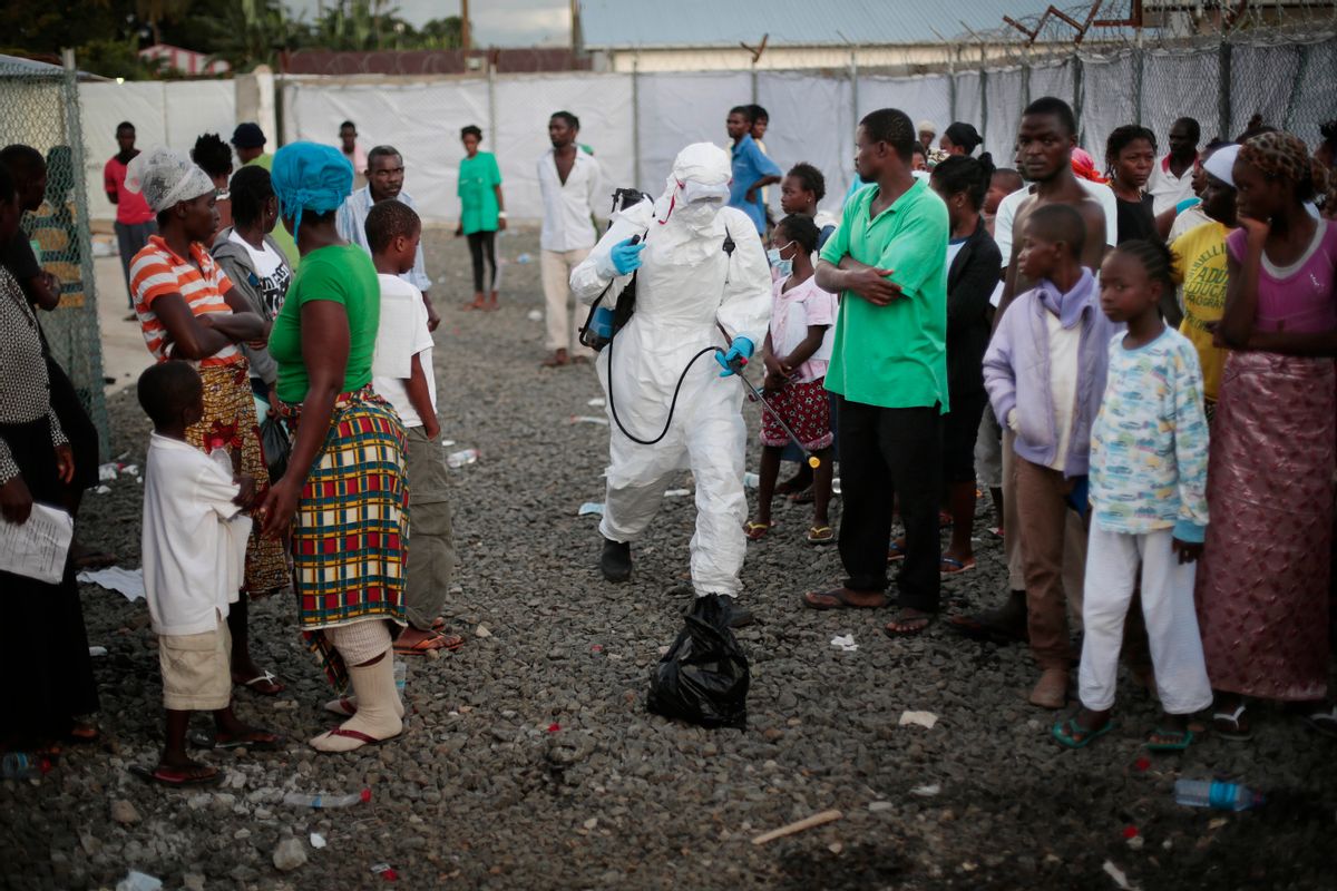FILE - In this file photo daetd Tuesday, Sept. 30, 2014, a medical worker sprays people being discharged from the Island Clinic Ebola treatment center in Monrovia, Liberia. Bulldozers on Wednesday April. 5, 2017 cleared the remains of a once busy Ebola treatment unit in Liberia, as health care workers, officials and some who were treated there gathered to mark the center's last day and official decommissioning. (AP Photo/Jerome Delay, FILE) (AP)