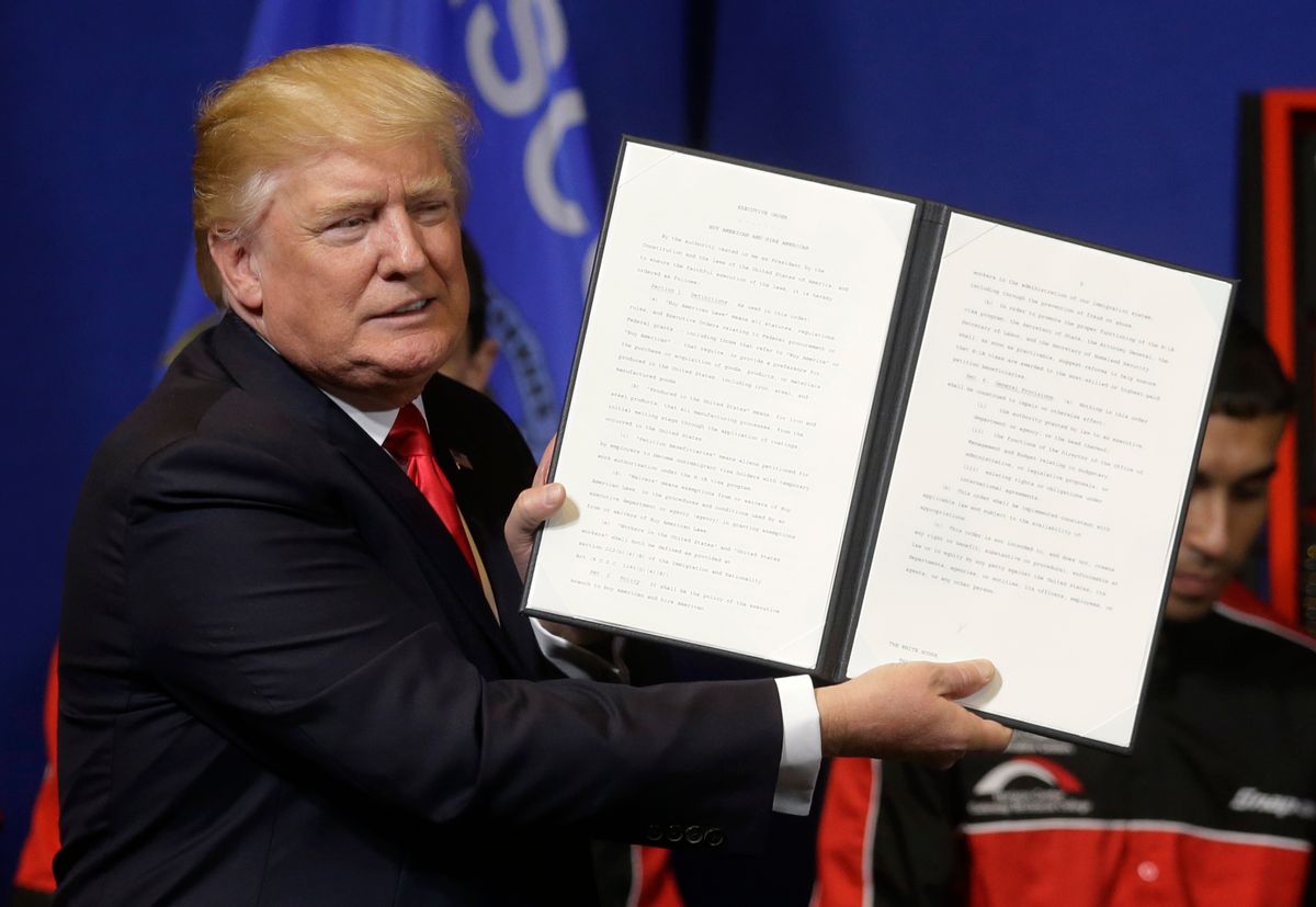 President Donald Trump holds up an executive order to tighten the rules for technology companies seeking to bring highly skilled foreign workers to the U.S., before signing, Tuesday, April 18, 2017, at Snap-On Tools in Kenosha, Wis. (AP Photo/Kiichiro Sato) (AP)