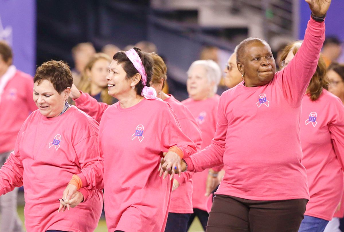Breast cancer survivors walk on the field before an NFL game (AP/Seth Wenig)