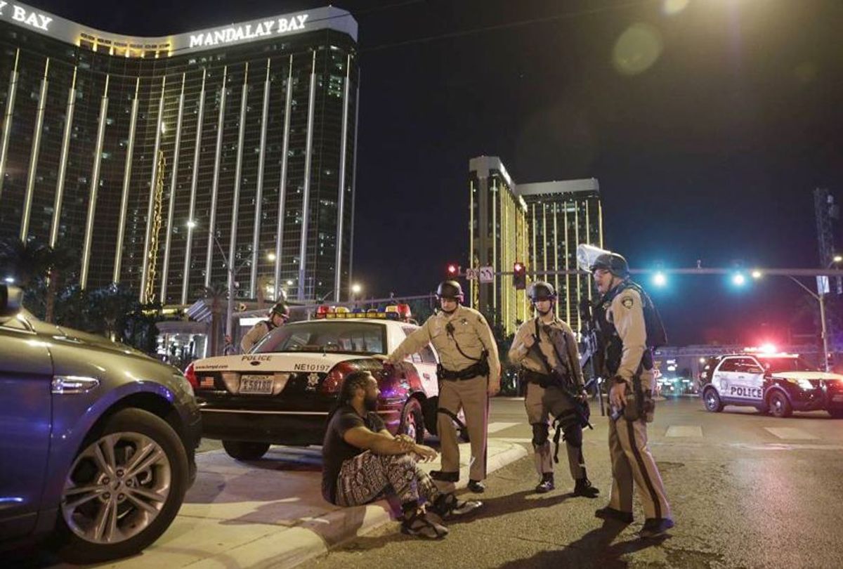 Police officers stand at the scene of a shooting near the Mandalay Bay resort and casino in Las Vegas, Oct. 1, 2017. (AP Photo/John Locher)