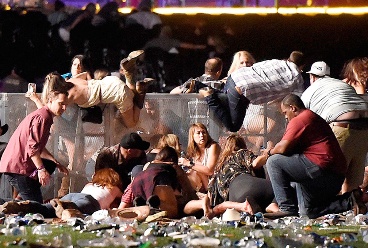 People scramble for shelter after gunfire at a country music festival on October 1, 2017. (Getty/David Becker)