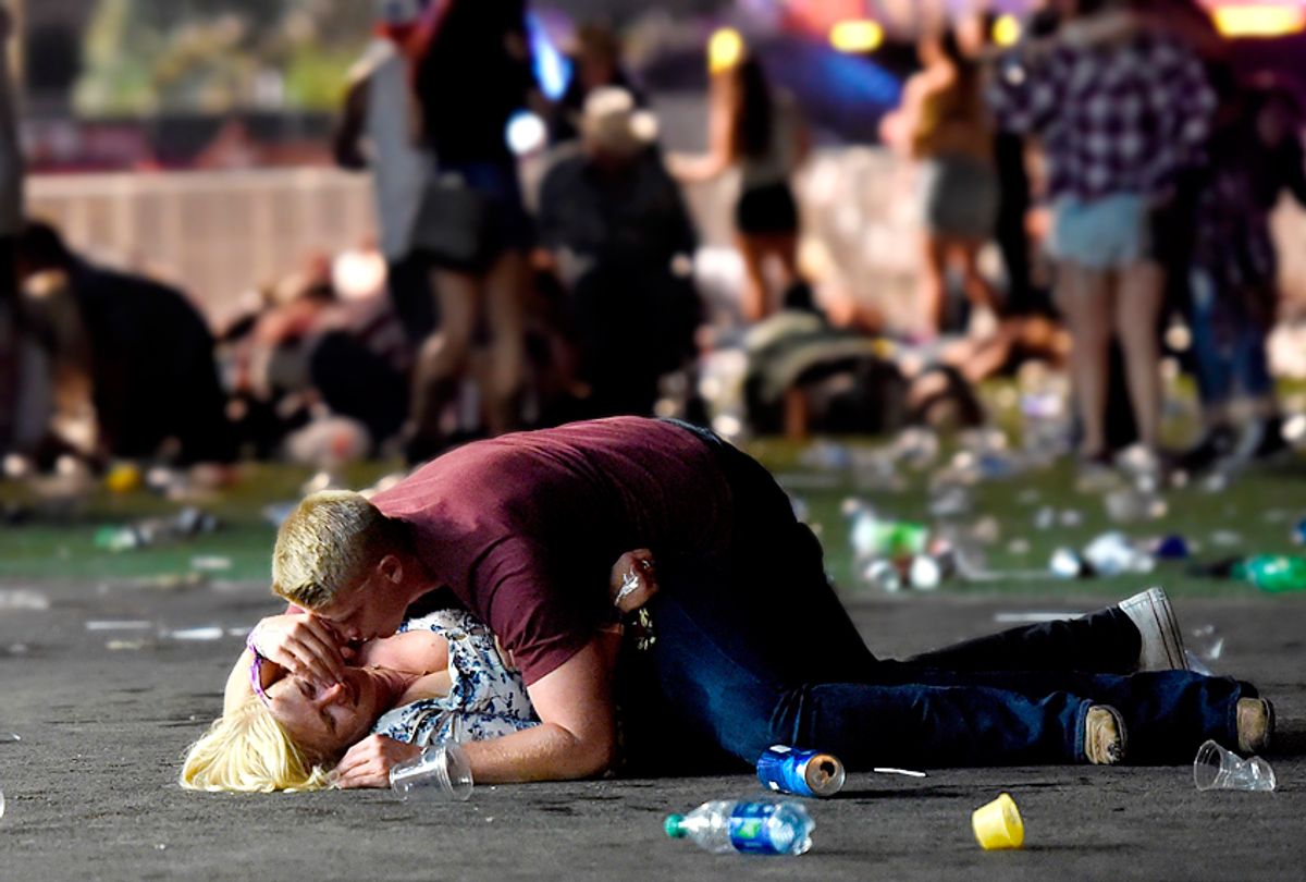 A man lays on top of a woman as others flee a country music festival after a shooting on October 1, 2017 (Getty/David Becker)