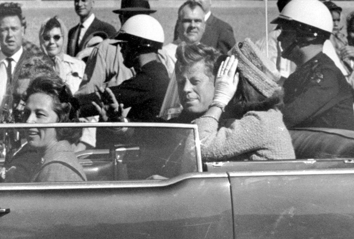 President John F. Kennedy, next to Jacqueline Kennedy, waves from his car in a motorcade in Dallas on Nov. 22, 1963 (AP/Jim Altgens)