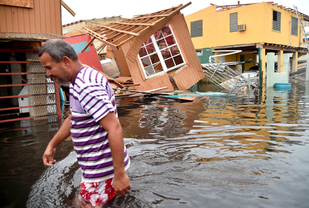 A man walks past a house laying in flood water in Catano town, in Juana Matos, Puerto Rico after Hurricane Maria (Getty/Hector Retamal)