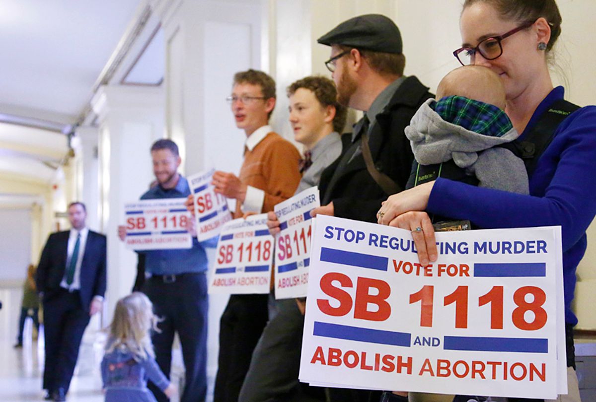 Anti-abortion activists stand outside the Oklahoma Senate chambers urging lawmakers to hear an anti-abortion measure that would make it a felony crime to perform an abortion (AP/Sue Ogrocki)