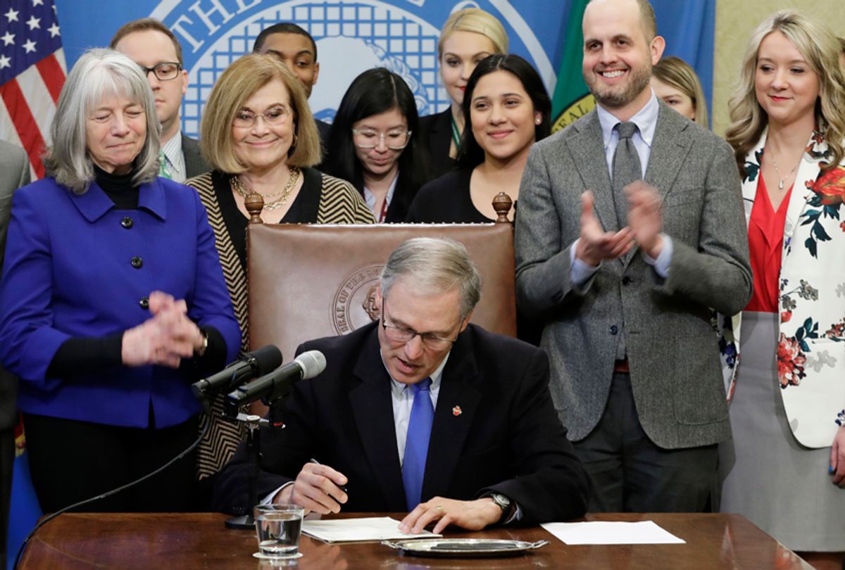 Washington Gov. Jay Inslee signs a bill March 5, 2018, that makes Washington the first state to set up its own net-neutrality requirements. (AP/Ted S. Warren)