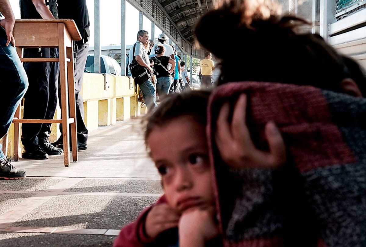 A Honduran child and her mother, fleeing poverty and violence in their home country, as they wait along the border bridge after being denied entry from Mexico into the U.S. (Getty/Spencer Platt)