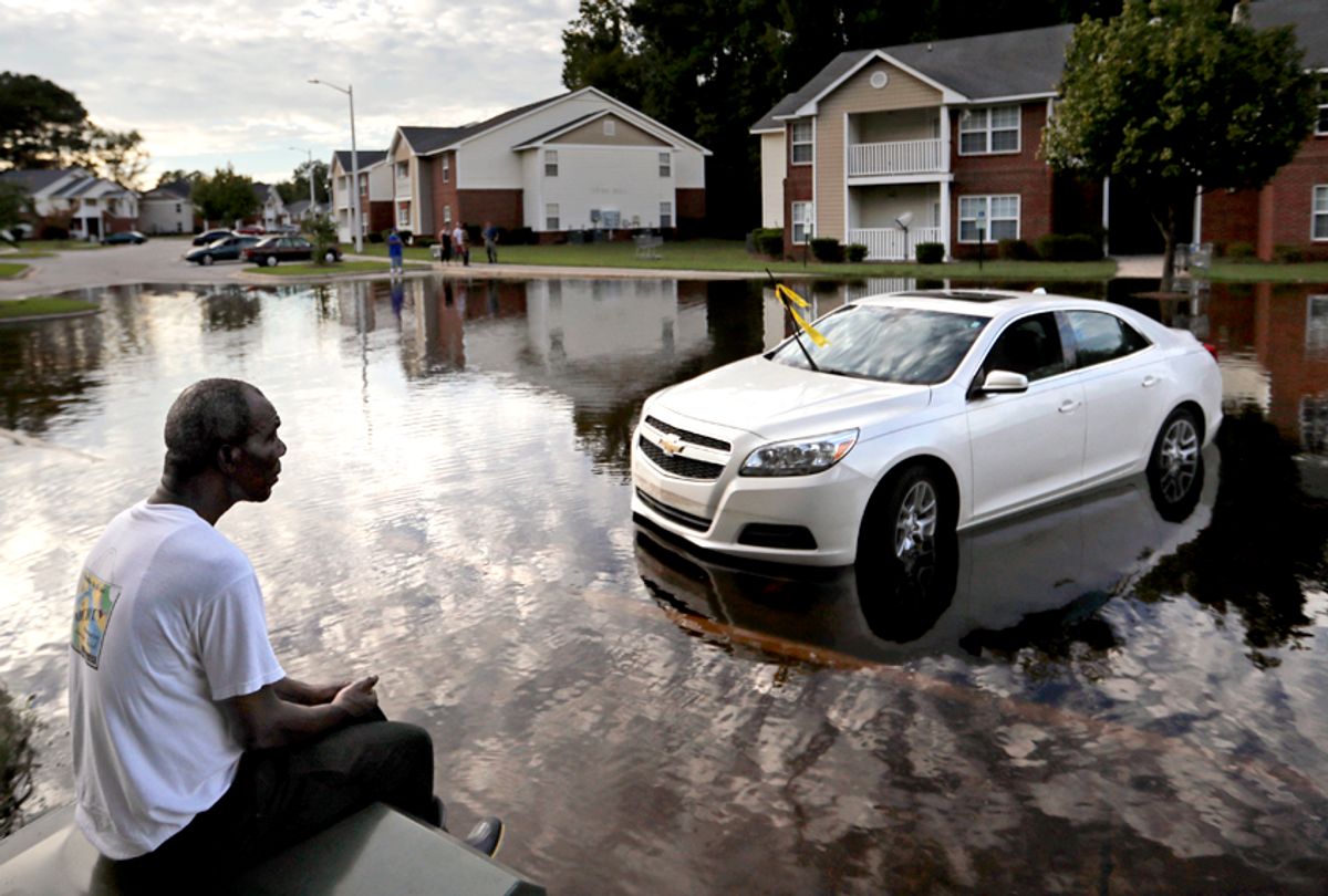 Augustin Dieudomme looks out at the flooded entrance to his apartment complex as it continues to rise in the aftermath of Hurricane Florence in Fayetteville, N.C., Sept. 18, 2018. (AP/David Goldman)