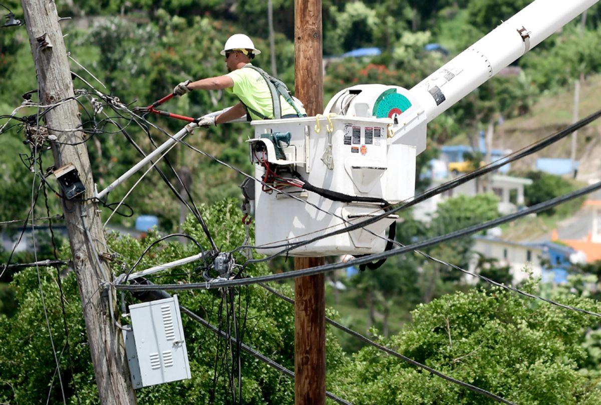 A worker from the Cobra Energy Company, contracted by the Army Corps of Engineers, installs power lines in the Barrio Martorel area of Yabucoa, a town where many residents continue without power in Puerto Rico. (AP/Carlos Giusti)