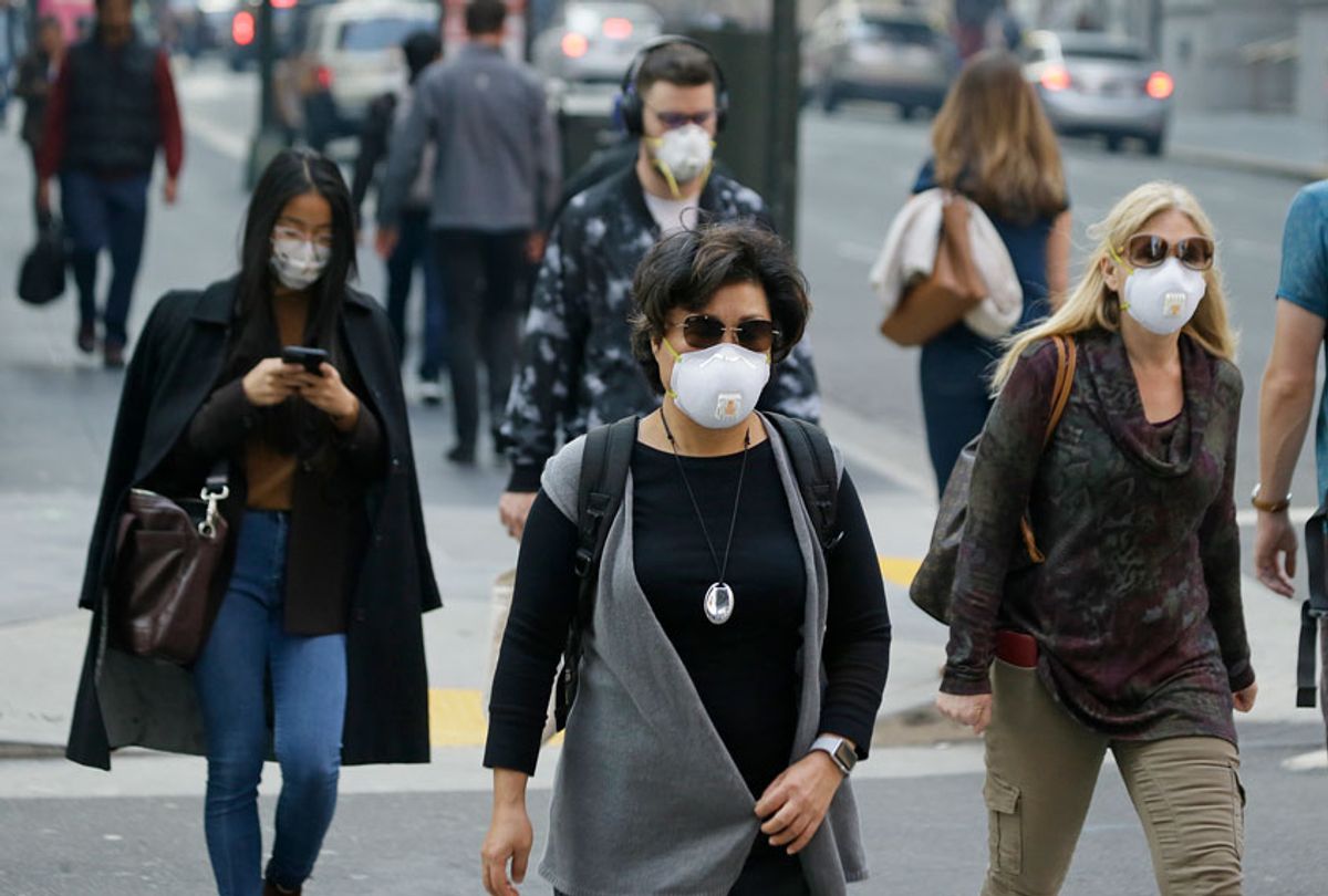 People wear masks while walking through the Financial District in the smoke-filled air Friday, Nov. 9, 2018, in San Francisco. (AP/Eric Risberg)